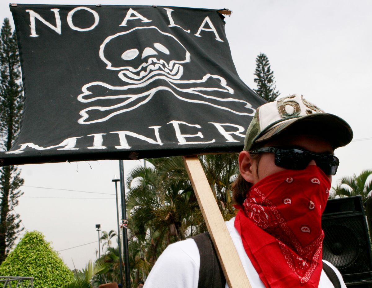 A protester holds a sign that reads in Spanish "No to mining" at a 2007 march against Canada's gold and silver mining operations in northern El Salvador, outside Canada's Consulate office in San Salvador.